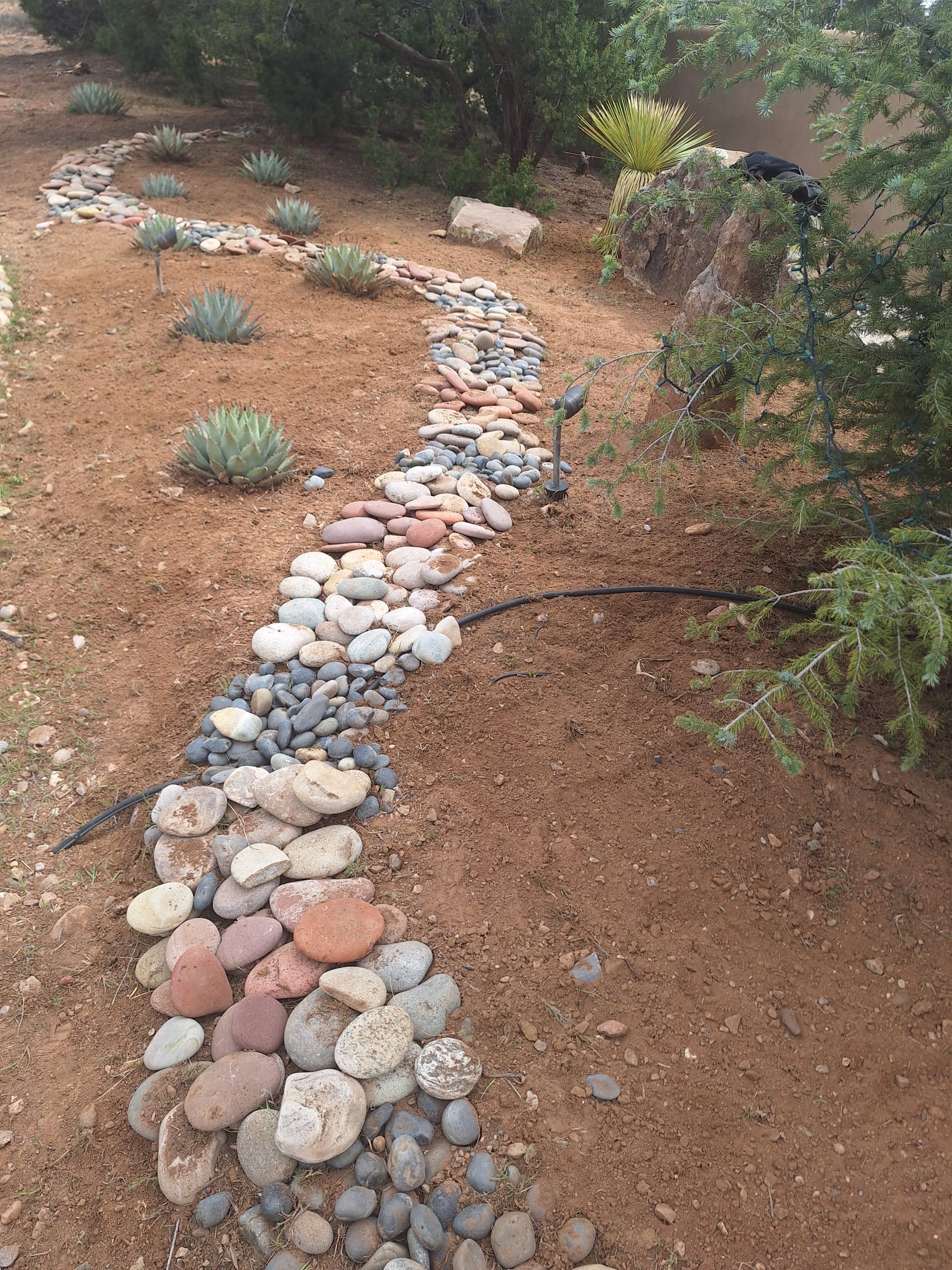 Beautiful dry creek bed and desert garden landscaping by Ruano's in Santa Fe